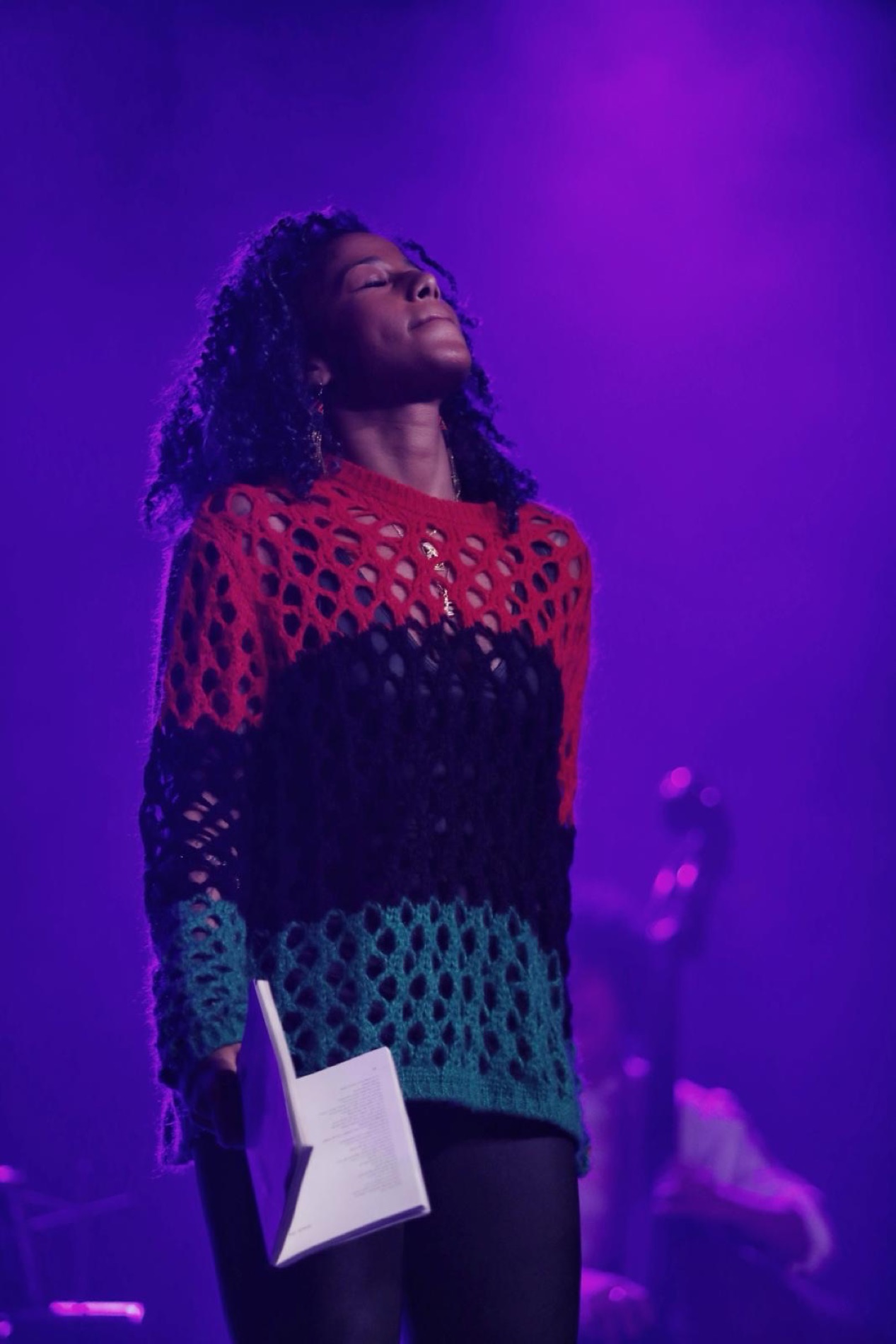 Aja Monet performing in purple stage light