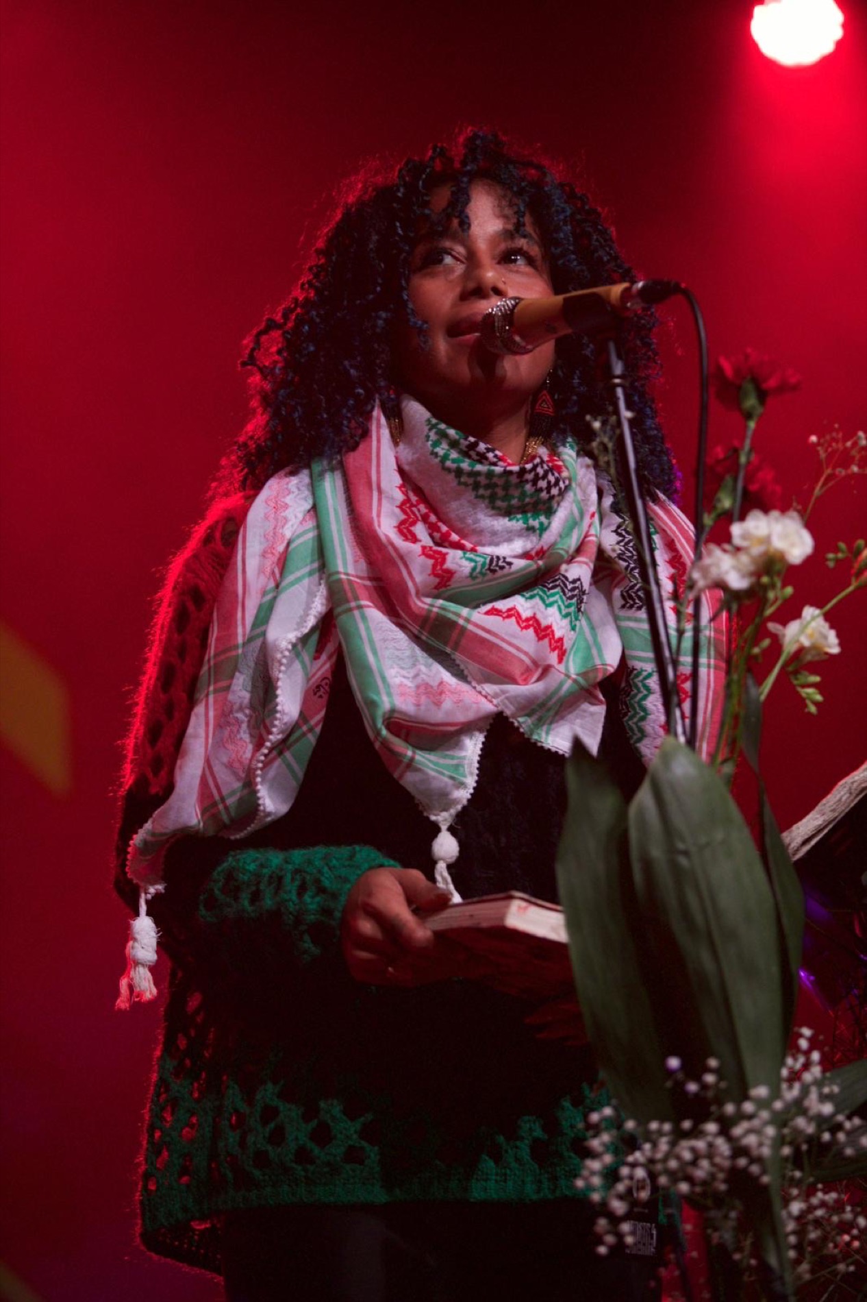 Aja Monet with flowers on stage