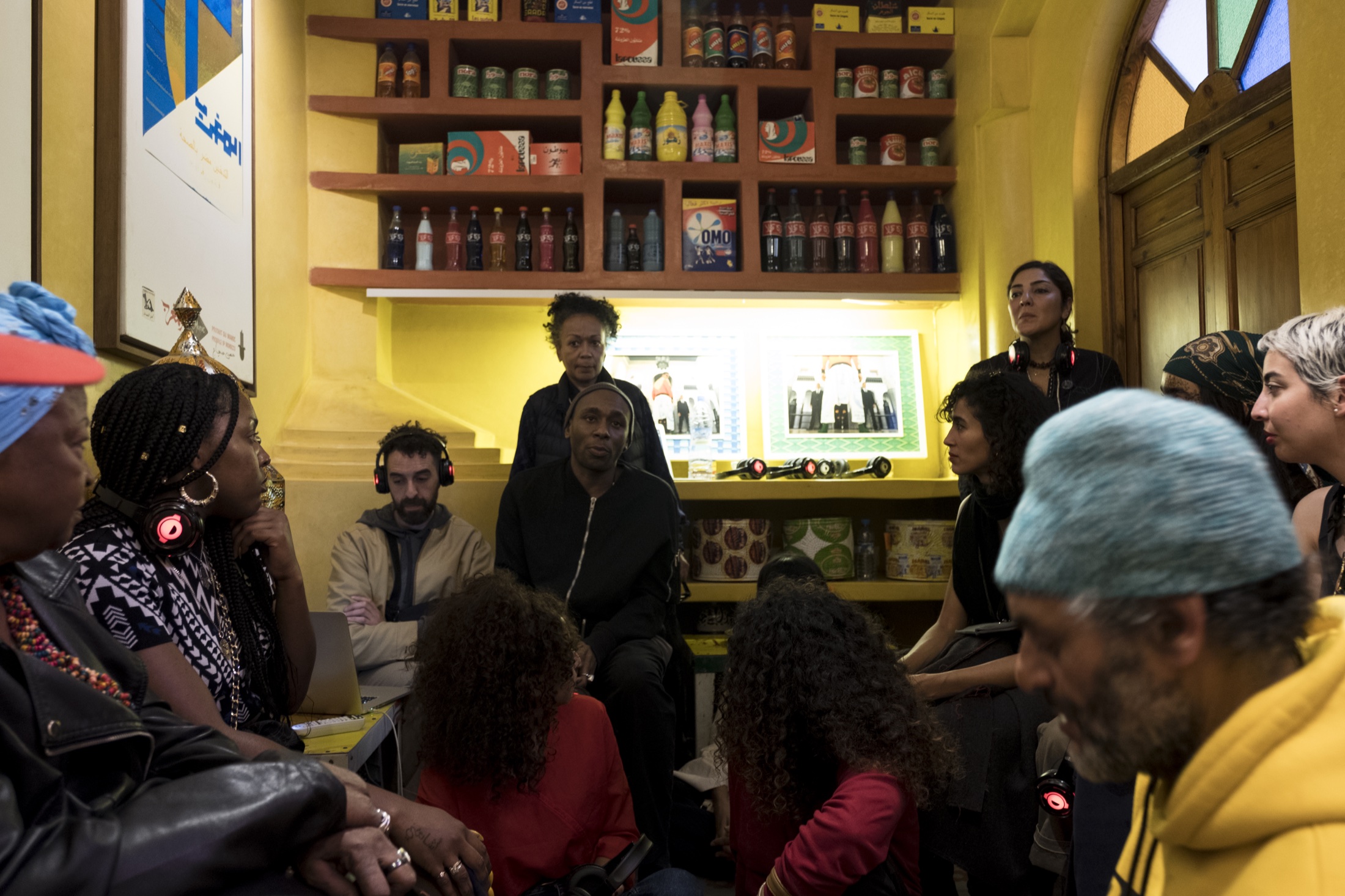 Yasiin Bey seated in conversation with visitors during the Marrakech Negus presentation